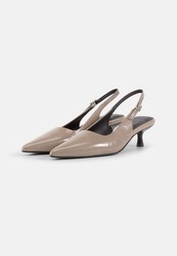 Beige patent leather slingback heels with a pointed toe and a small tapered heel, featuring a side buckle strap and sleek design.