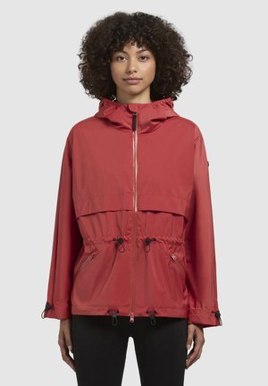 Red waterproof jacket featuring a hood, front zipper, elastic drawstring waist, and two side pockets with cord locks for adjustability.