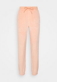 Ljust rosa, mjuka velour-joggingbyxor med elastisk midja, dragsko och avslutade anklar. Har en liten logotyp på vänster ben.
