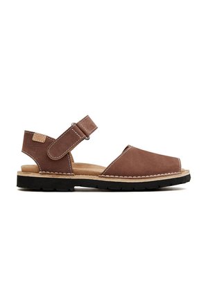 Sandalia de cuero marrón con puntera cerrada, correa ajustable y suela de goma texturizada. Los detalles de costura en contraste realzan el diseño.