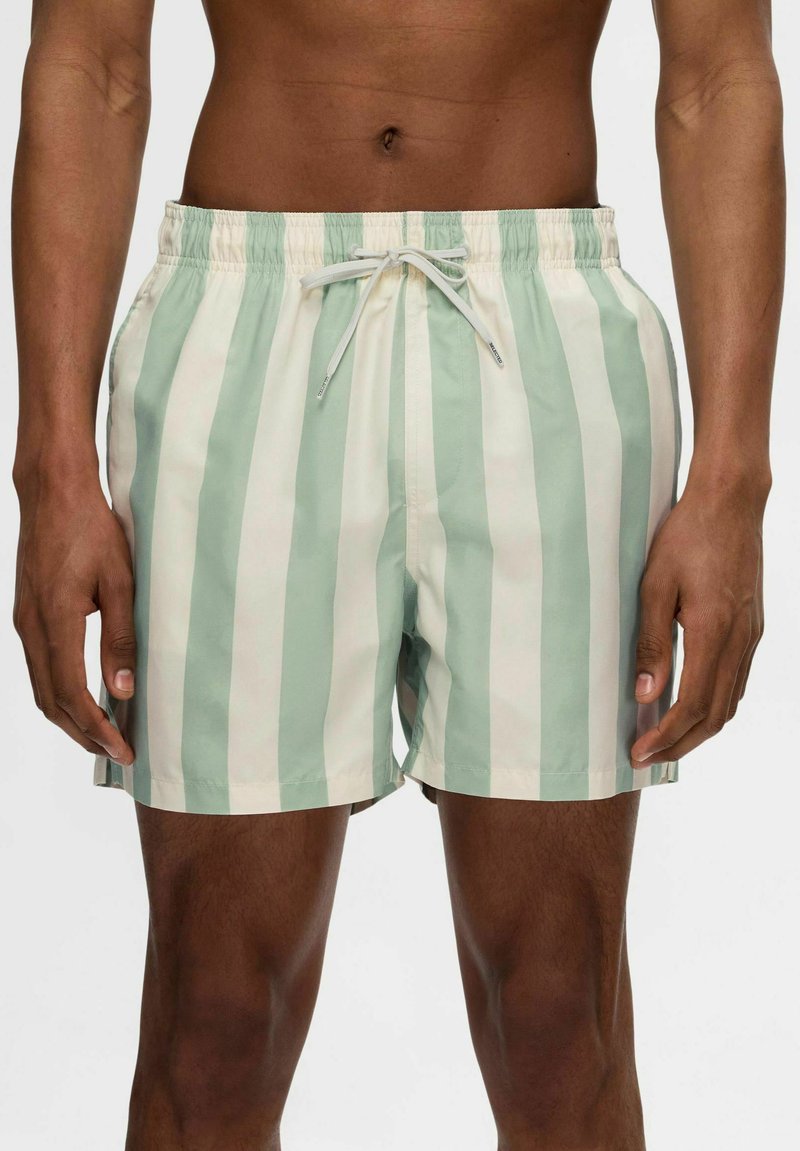 Gestreifte Badeshorts in Hellgrün und Creme, aus leichtem Stoff gefertigt, mit elastischem Bund und verstellbarem Kordelzug.