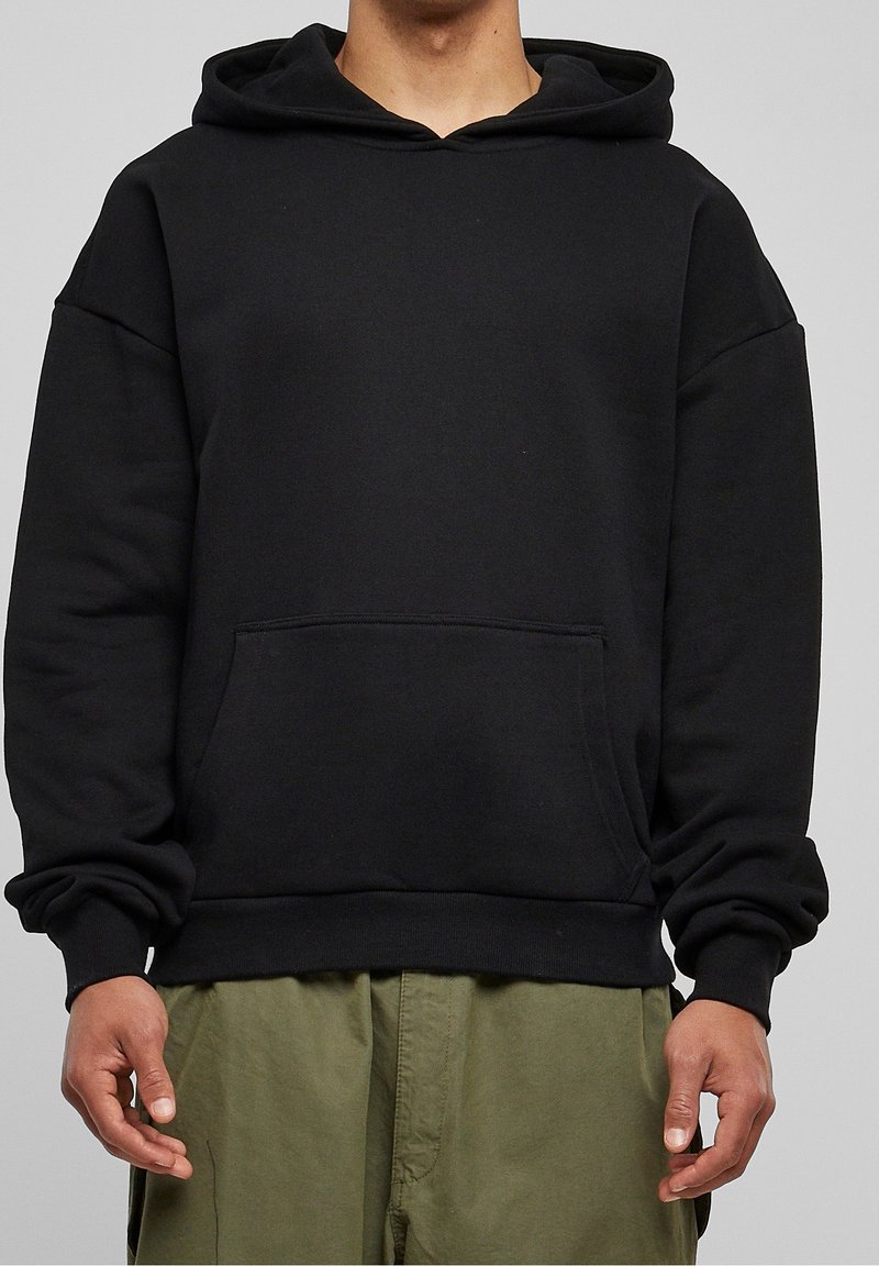 Czarna bluza z kapturem z przodu, z kieszenią, o luźnym kroju i ściągaczami przy mankietach. Wykonana z miękkiego materiału, charakteryzuje się gładką fakturą i minimalistycznym wzornictwem.