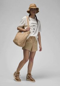 Beige bucket hat, white t-shirt with black text, beige shorts, and brown high-top sneakers. Carrying a tan shoulder bag, texture is smooth.