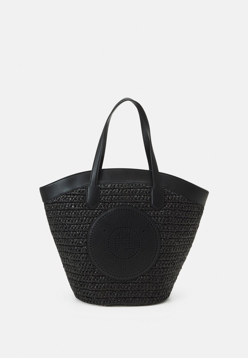 Sac cabas en tissu noir avec poignées noires lisses et écusson logo circulaire perforé au centre avant.