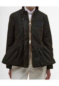 Donkergroene jas met een peplum ontwerp, ritssluiting en een geborduurd merkembleem. Voorzien van goudkleurige accenten en een gestructureerde stof.