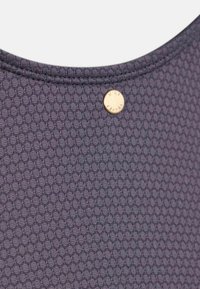 Tumehall tekstuuriga kangas heksagonaalse mustriga, mille kaelusel on väike ümmargune metallist logoembleem.