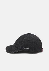 Gorra de denim negro con visera curvada, que presenta el logo blanco de "Levi's" en la parte frontal. Textura suave con detalles de costura visibles.