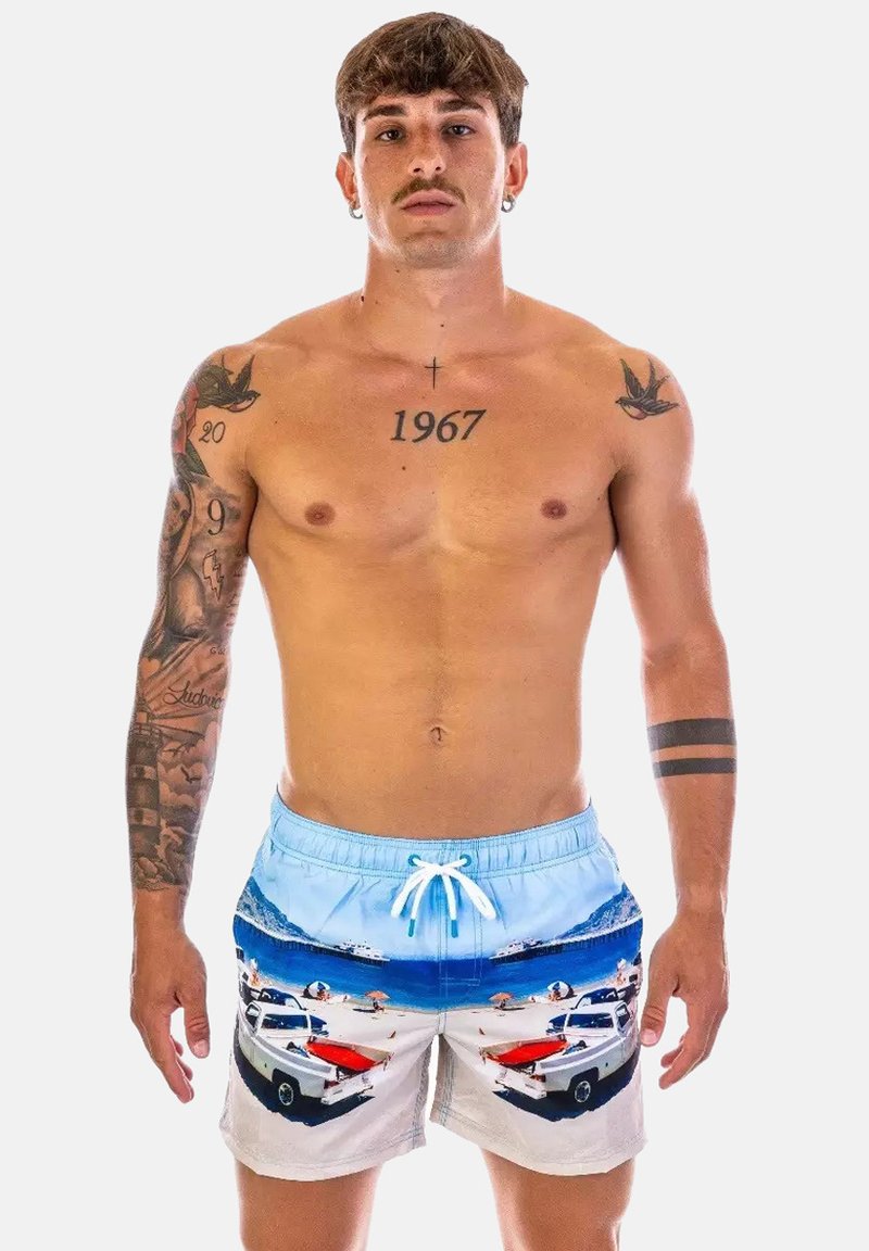 Pantaloni da nuoto in un design blu chiaro e bianco, che presenta una scena di spiaggia con auto e barche. Realizzati in materiale leggero, con vita elastica.