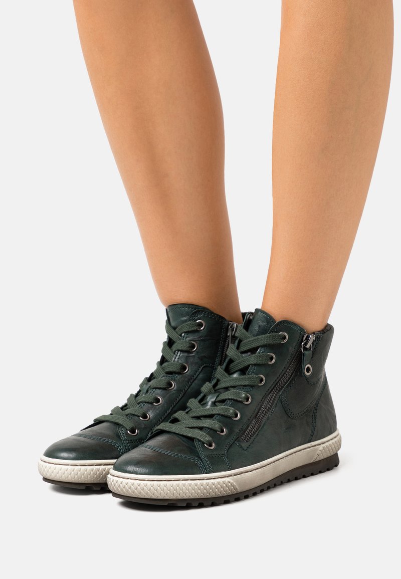 Green leather high-top sneakers with contrasting textured rubber soles, lace-up design, side zipper, and rounded toe.