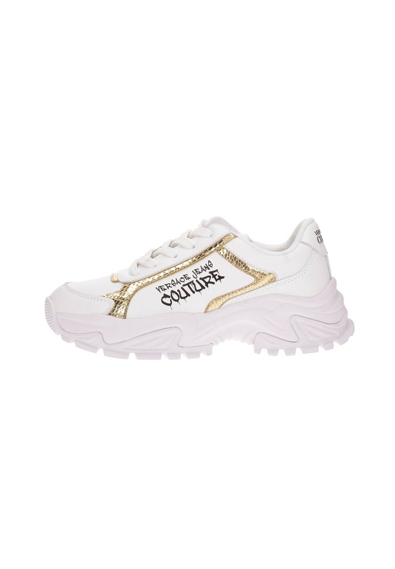 Sneaker bianca con accenti dorati e testo nero. Presenta una parte superiore testurizzata, una suola spessa con un motivo a onda e lacci. Ha un design contemporaneo.