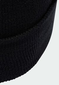 Schwarze Strickmütze mit gerippter Textur und umgeschlagenem Saum, entworfen für Wärme und Komfort. Das Material wirkt weich und dehnbar.