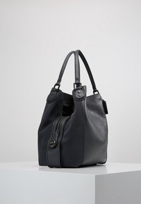 Czarna skórzana torebka o teksturowanej powierzchni, z dwoma krótkimi uchwytami, zamkiem błyskawicznym po jednej stronie oraz subtelnymi metalowymi elementami.