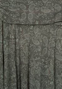 Szürke szövet, világoszöld virágos paisley mintával. Puha tapintás, eső, redők és hajtott rész a tetején.