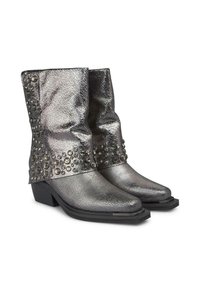 Metaliczne srebrne kowbojki z teksturowanym wykończeniem, z czarnymi ćwiekami po bokach i niskim słupkowym obcasem. Smukły, spiczasty nos.