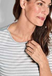 Lichtgrijs gestreept topje met een wijde halslijn en korte mouwen, gemaakt van zacht fabric. Het ontwerp heeft horizontale strepen in verschillende breedtes.