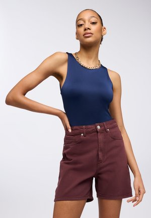 Body senza maniche blu marina abbinato a shorts in denim bordeaux a vita alta, con tasche frontali e dettagli in bottone argentato. Texture liscia.