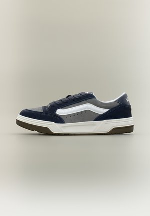 Lavsko fra Vans i marineblå og grå med hvit side stripe og tykt hvitt såle på ensfarget bakgrunn.