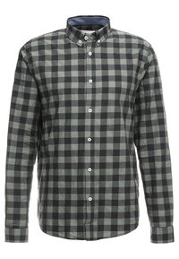 Vihreä-musta ruudullinen paita, pitkät hihat, nappikaulus, puuvillakangasta, valkoiset napit ja tummempi kauluksen vuori kontrastivärillä.