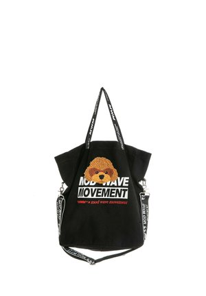 Bolsa tote negra con parche marrón con la cara de un perro, texto blanco y rojo "Mod Wave Movement" y asas negras con texto blanco.