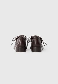 Pair of dark brown leather dress shoes with laces, viewed from the back, placed side by side on a white background.