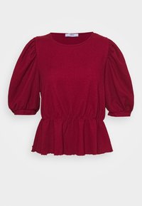 Rød tekstureret top med puffede ærmer og peplum-kant; har en rund halsudskæring og strækstof for komfort. Mærket er synligt på kraven.