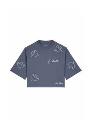 T-shirt court bleu avec des colombes en art linéaire blanc et le mot "Liberté" imprimé sur le devant, avec un col rond et des manches courtes.