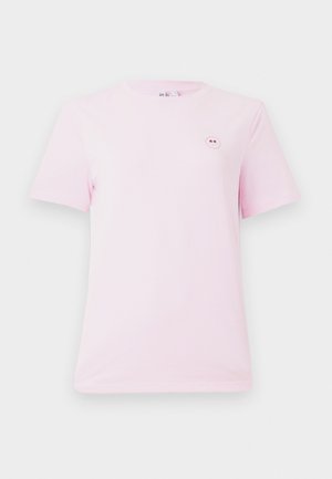 T-shirt rose clair à manches courtes en coton, avec un petit motif de smiley rond sur la poitrine gauche. Texture douce et coupe standard.