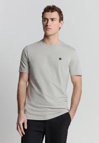 Lichtgrijze t-shirt met korte mouwen, voorzien van subtiele verticale strepen, een ronde halslijn en een klein zwart hexagonaal logo op de borst.