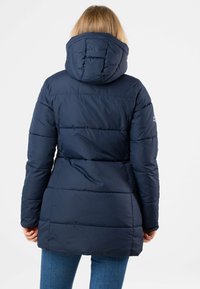 Navy blue puffer jacket with a hood, featuring quilted sections and a fitted waist design, extending to mid-thigh length.