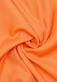 Tessuto arancione brillante, texture liscia, tessuto a trama stretta, drappeggiato a forma di spirale, che mostra la flessibilità e la lucentezza del materiale.