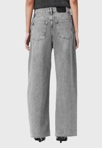Grijze high-waisted wijdlijn jeans met een rafelige zoom, denim materiaal, twee achterzakken en een label aan de tailleband.