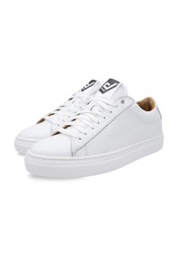 White leather sneakers with a textured side, round toe, flat rubber sole, and contrasting logo accents on the top. Laced design.