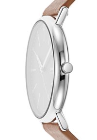 Montre en métal argenté au design minimaliste, cadran blanc et bracelet en cuir marron. Elle présente de fins index horaires et un détail de couronne.