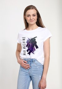 Bílý tričko s krátkým rukávem, na kterém je grafika postavy v šedé a fialové barvě s textem "WAR MACHINE" v černé. Viditelné džíny.