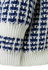 Strickpullover mit weißem Grund und blauen geometrischen Mustern, gerippten Bündchen und strukturiertem Stoff, der Handwerkskunst und Detailverliebtheit hervorhebt.