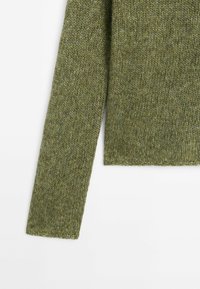 Green knitted sweater with a textured finish, featuring long sleeves and a cropped hem. The material appears soft and warm.