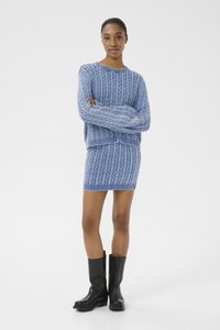 Jersey de punto en azul claro y falda a juego con bordes acanalados, combinados con botas de cuero negras hasta la rodilla.