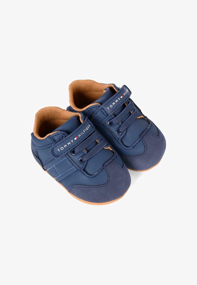 Sneakers per toddler di colore blu navy realizzati in materiale sintetico liscio con una fodera interna marrone, dotati di chiusura con lacci e suola in gomma.