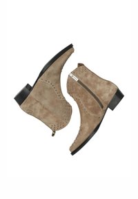 Botas de tobillo de ante beige con tachuelas metálicas, cremallera lateral, tacón bajo negro y punta redondeada, mostradas desde vistas lateral y inferior.
