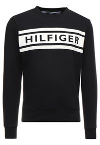 Sudadera negra hecha de tela suave, con una amplia banda blanca que lleva impreso en letras negras en negrita "HILFIGER" en el pecho. Cuello redondo.