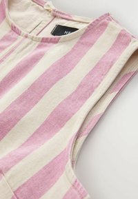 Vêtement sans manches, rayé verticalement rose et blanc, col rond avec un bouton en tissu dans le dos.