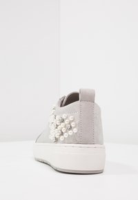 Jasnoszare zamszowe sneakersy z białą platformą, udekorowane skupiskiem białych pereł i małych kryształków na boku.