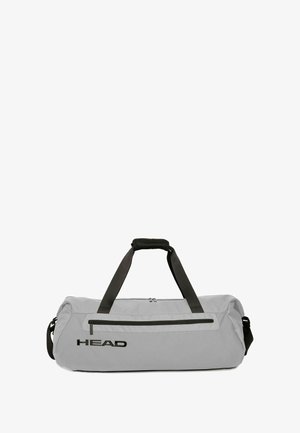 Sac polochon gris en matériau durable, équipé de ferrures noires, d'une poche avant zippée, de deux poignées et d'une bandoulière réglable.