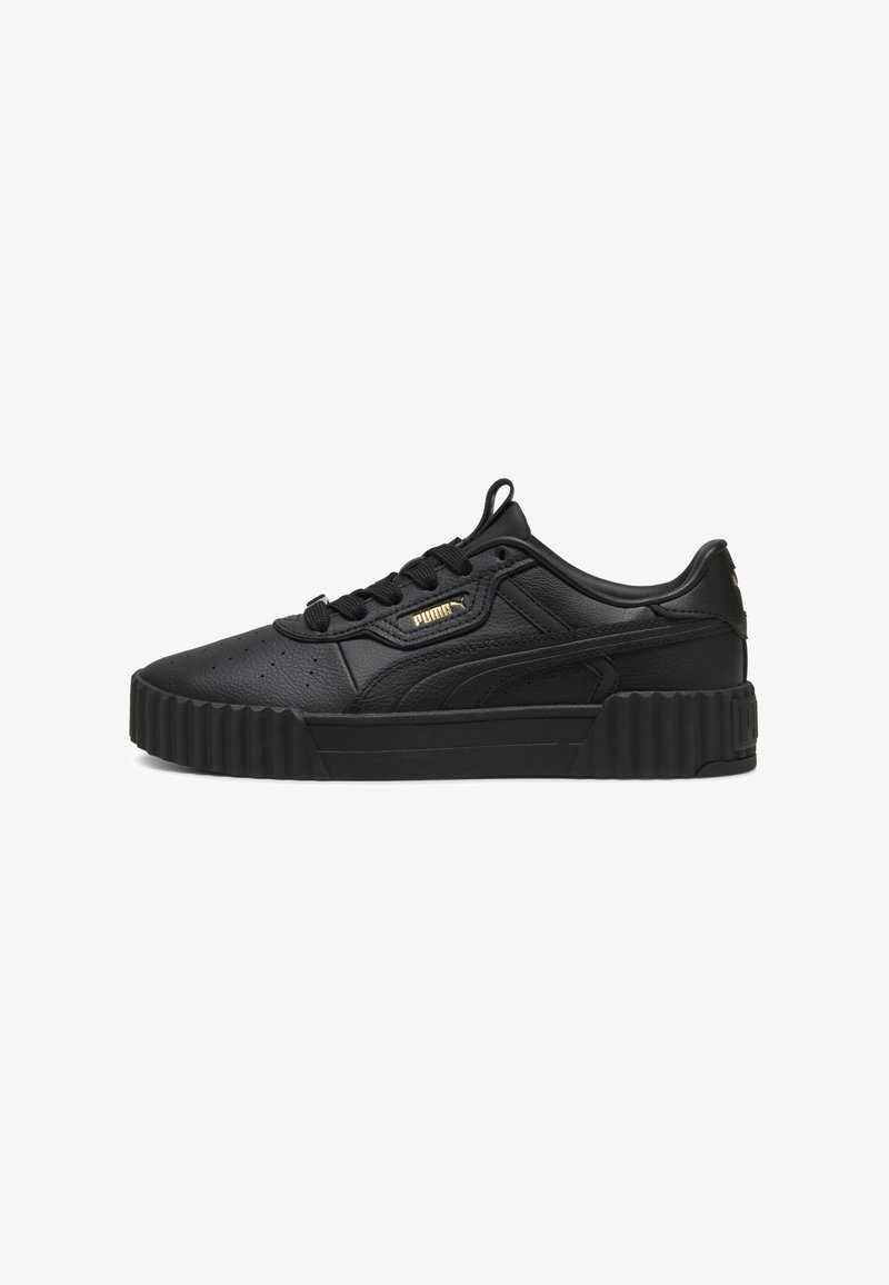 Schwarze Sneaker aus synthetischem Leder mit durchlochten Details, dickem geripptem Sohlen, flachen Schnürsenkeln und ein kleines goldenes Logo an der Seite.