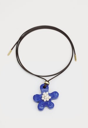 Pandantiv în formă de floare albastră, realizat din ceramică, decorat cu mici perle albe în centru, suspendat pe un șnur din piele maro cu accente aurii.