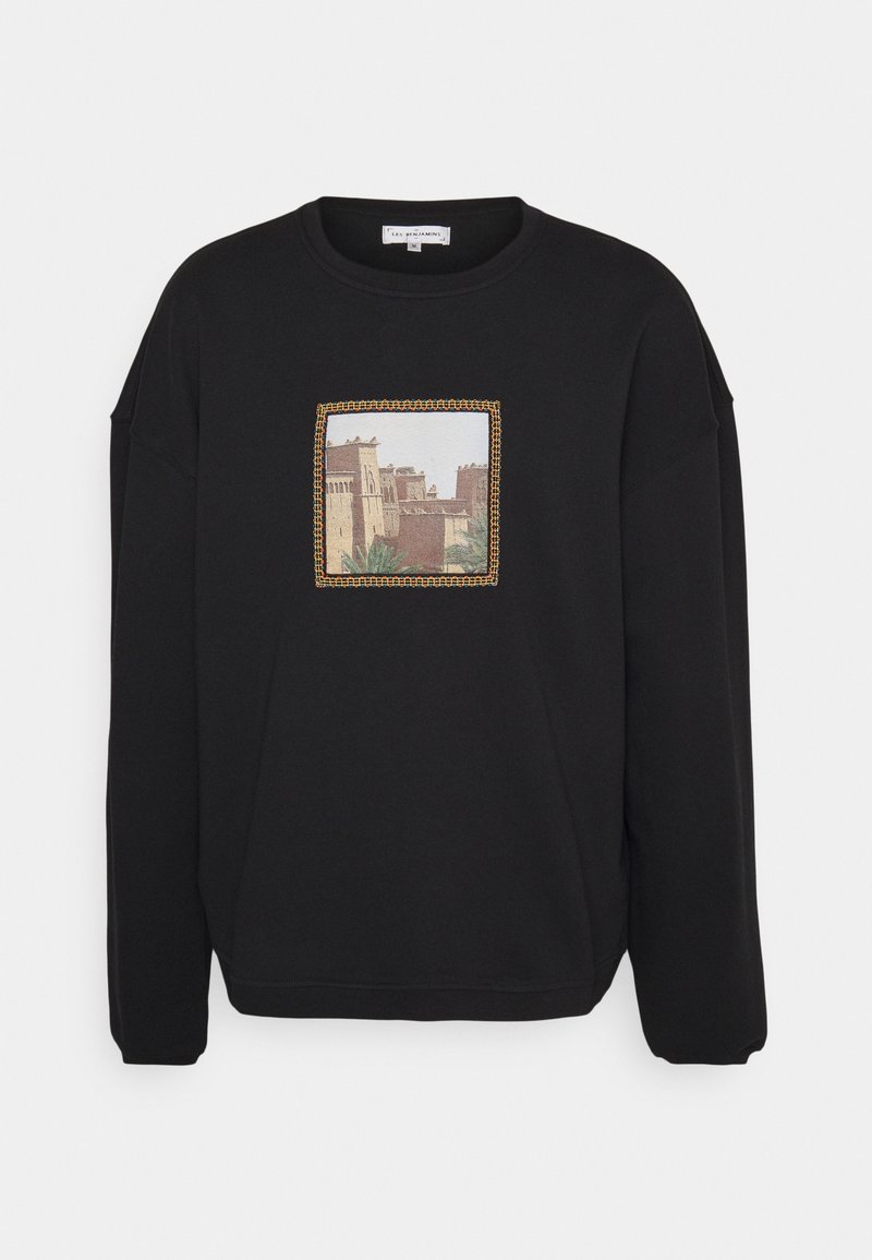 Sweat-shirt noir à coupe carrée, présentant un motif de paysage imprimé encadré par un motif tissé. Col rond et poignets côtelés.