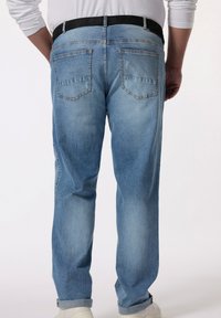 Jeans de mezclilla azul claro con corte recto, con una cinturilla negra, dos bolsillos traseros y bajos arremangados.