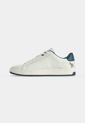 Άσπρο δερμάτινο sneaker χαμηλής κορυφής με ναυτικό μπλε ταμπ του τακουνιού, κορδόνια και λεπτομέρειες στη σόλα, με μικρό λογότυπο ζέβρας κοντά στη φτέρνα.