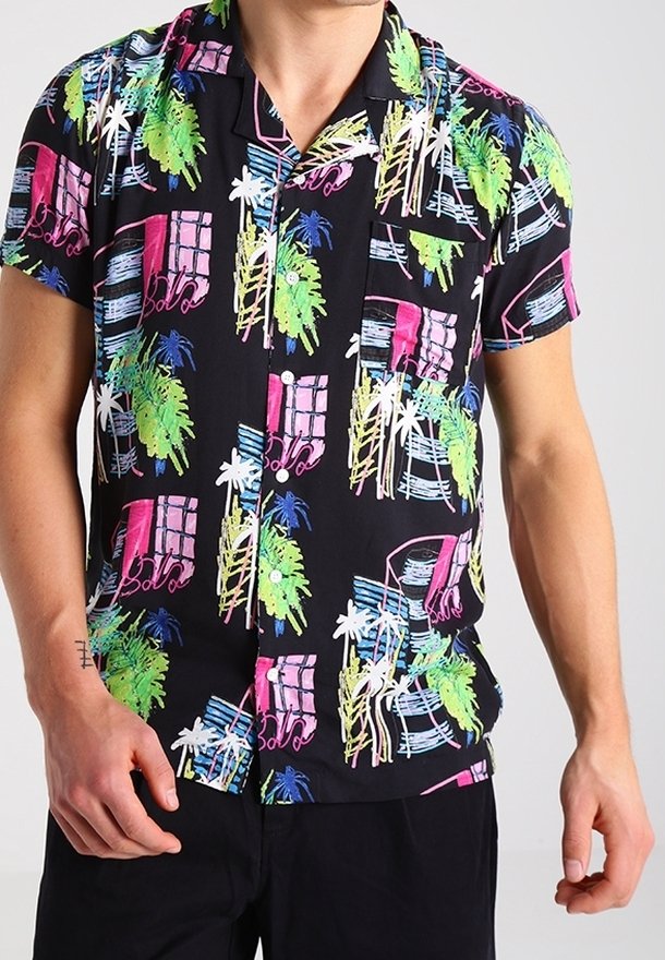 Camisa de manga corta hecha de tela ligera, con fondo negro y estampados tropicales coloridos en rosa, verde y azul.