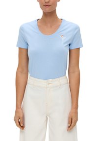 Hellblaues kurzärmeliges T-Shirt mit Rundhalsausschnitt und weißer "Good Times"-Cocktailgrafik. Kombiniert mit hochgeschnittenen weißen Hosen.
